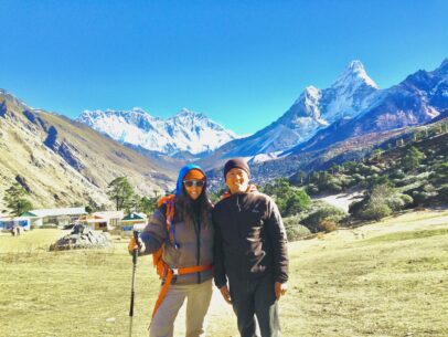 2 trekkers in front of mountains