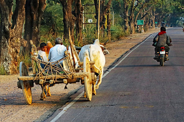 A hand-made wagon carries a family