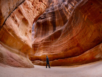 Man standing at the bottom of narrow canyon