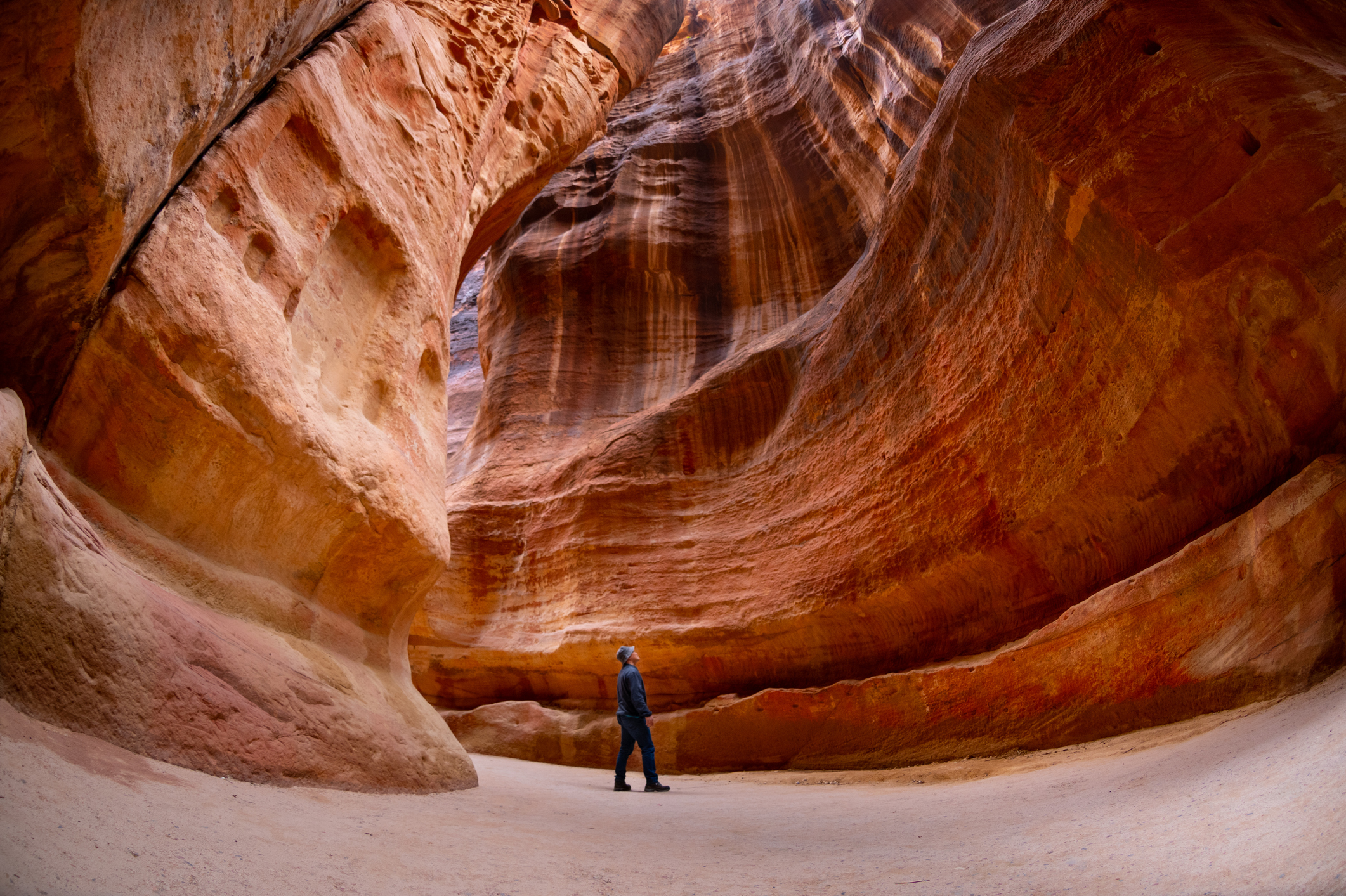 Man standing at the bottom of narrow canyon