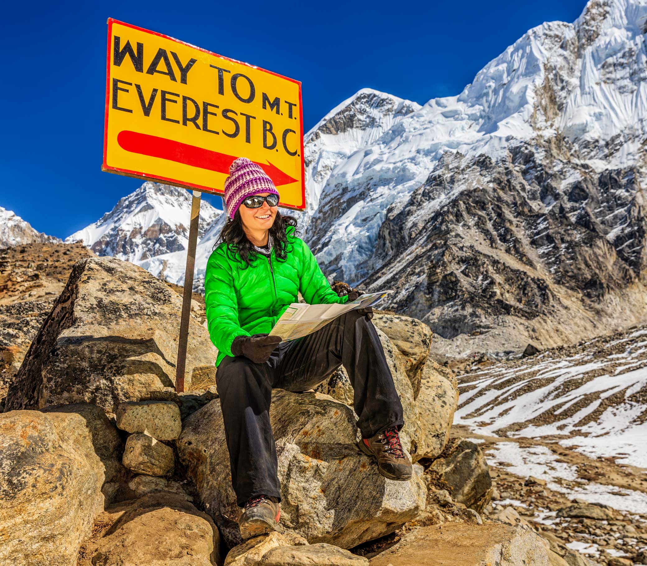 Young woman, wearing green jacket, is sitting and studying map in Himalayas, Signpost "Way to Mount Everest Base Camp" on the background. Mount Everest National Park. This is the highest national park in the world, with the entire park located above 3,000 m ( 9,700 ft). This park includes three peaks higher than 8,000 m, including Mt Everest. Therefore, most of the park area is very rugged and steep, with its terrain cut by deep rivers and glaciers. Unlike other parks in the plain areas, this park can be divided into four climate zones because of the rising altitude.