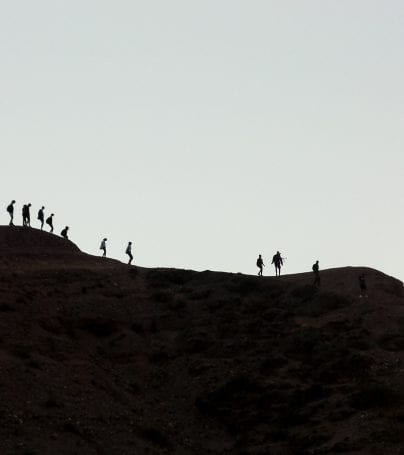 People walk along ridge of Purmamarca, Argentina