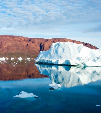 View of ice and mountains across water in Scoresbysund