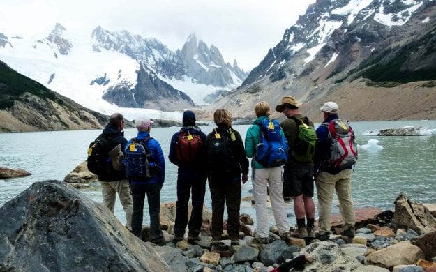 Argentina hiking group stands in front of mountain lake