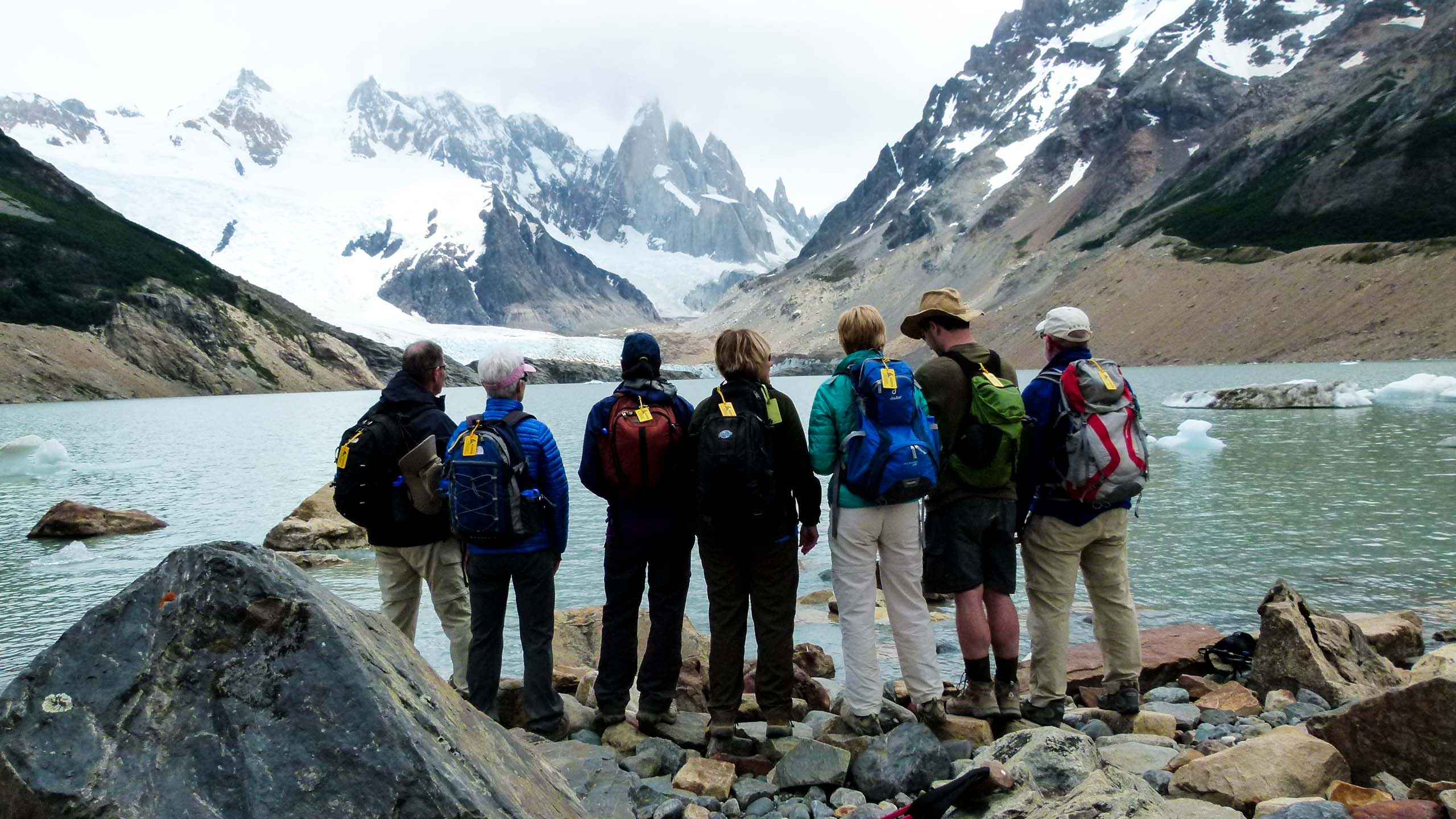 Argentina hiking group stands in front of mountain lake