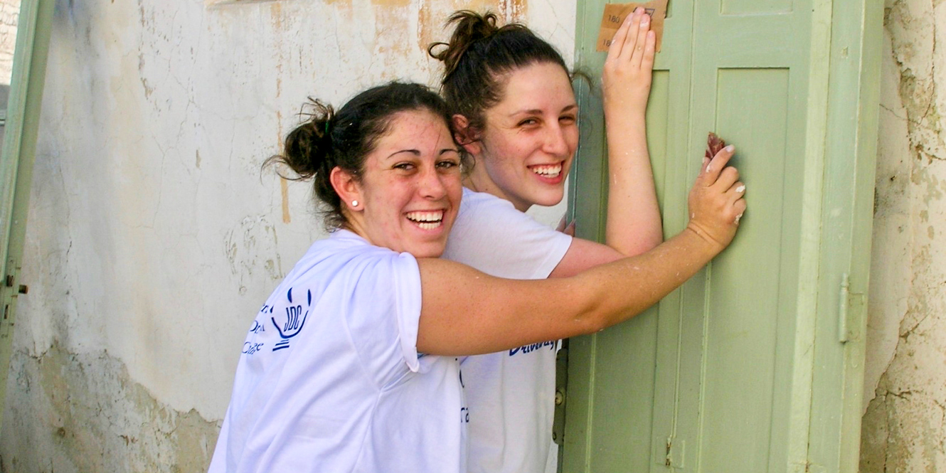 Smiling college students lean against door