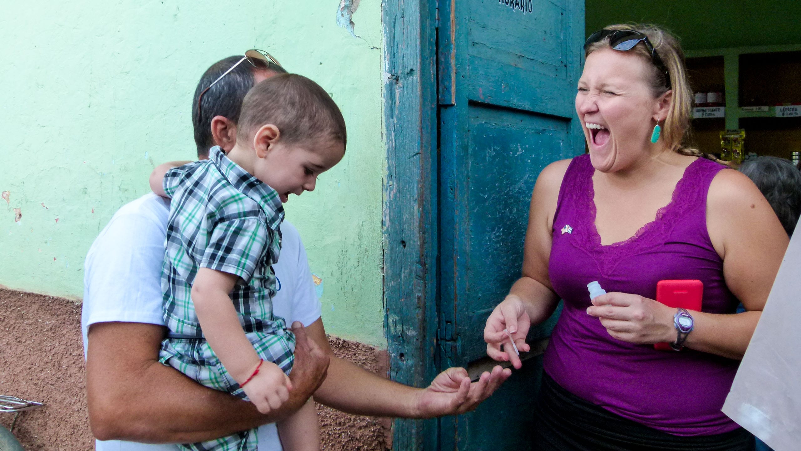 Laughing woman helps man with baby