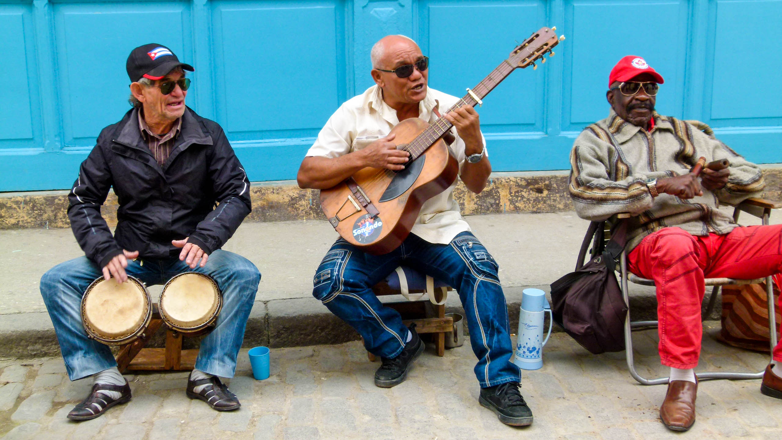 Men play instruments on Cuba street curb