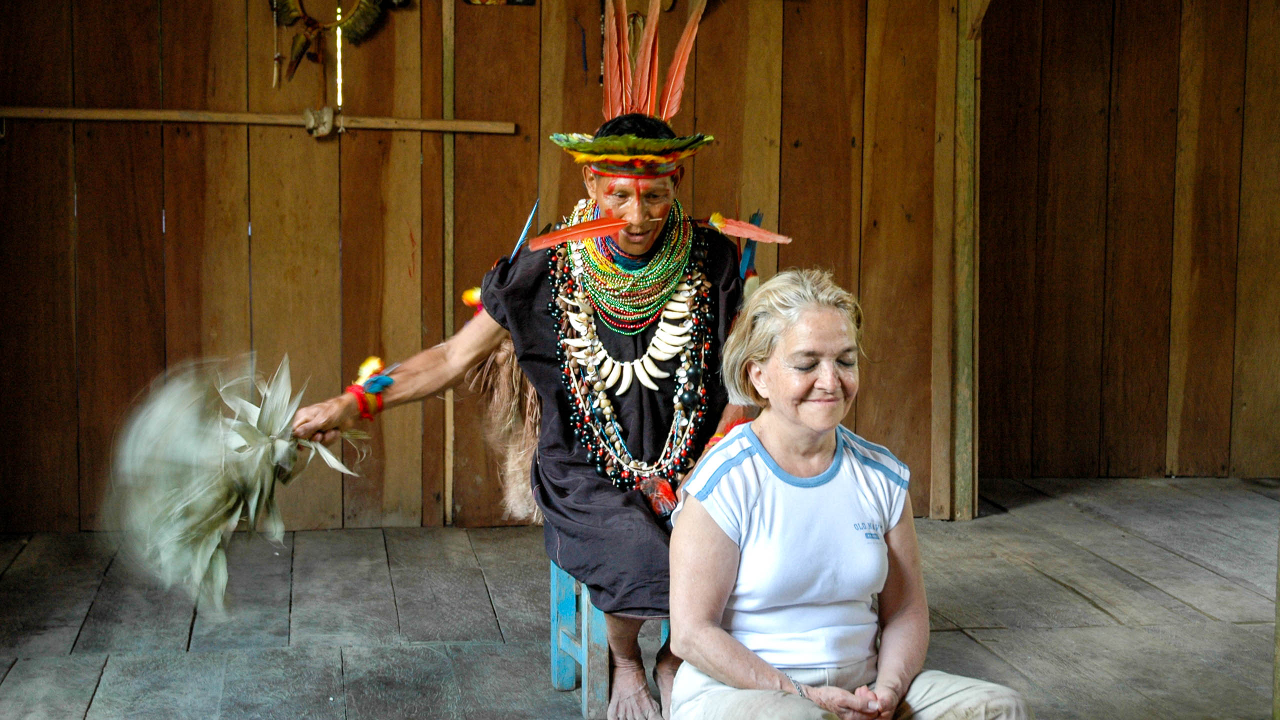 Woman sits in front of Ecuador man in traditional dress