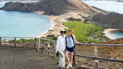 Woman and teen stand in front of Galapagos landscape
