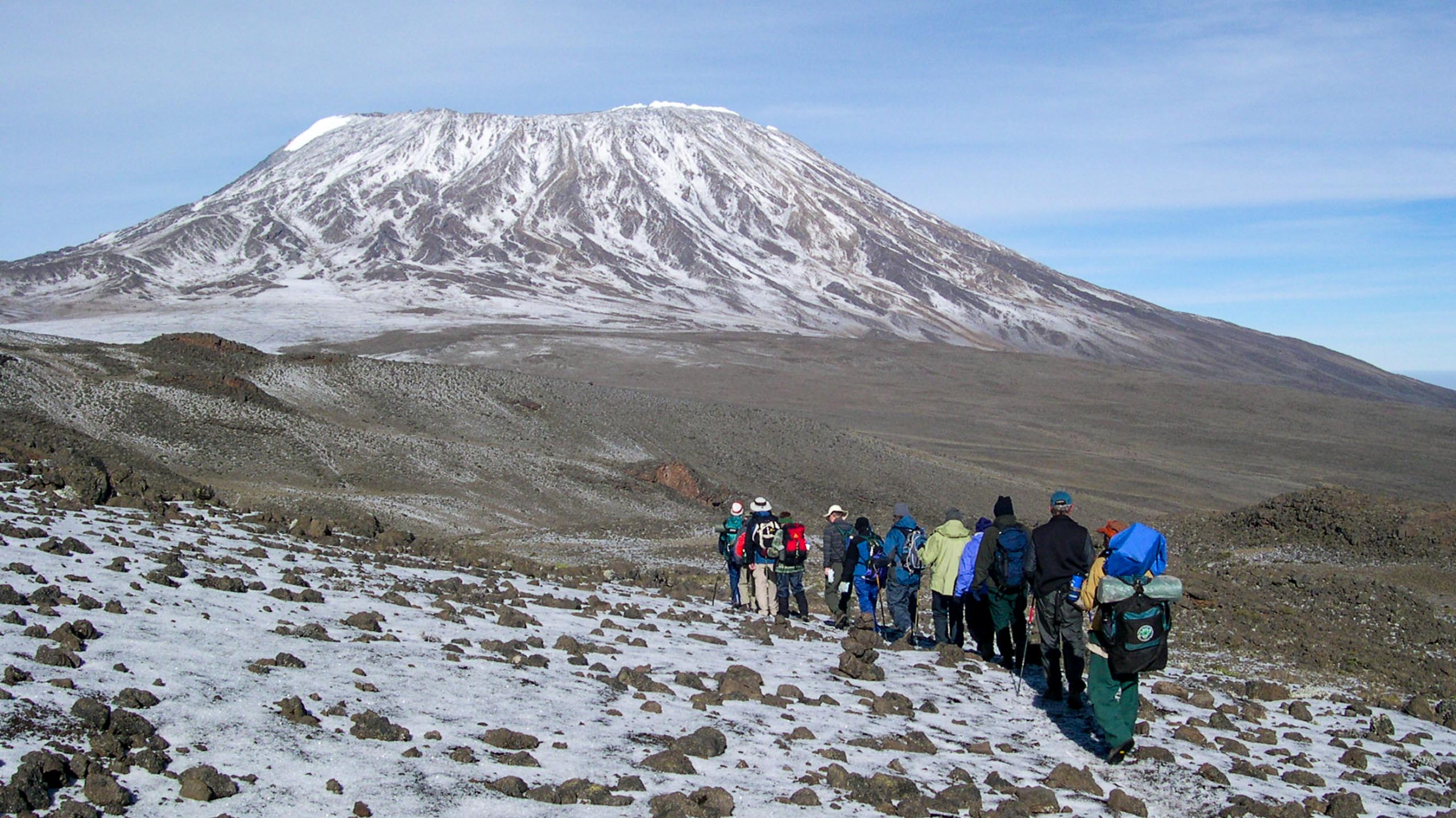 Group of travelers hike toward Mt Kilimanjaro