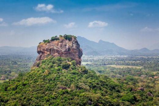 Spectacular view of the Sigiriya Lion rock surrounded by green rich vegetation. Picture taken from Pidurangala mountain in Dambula