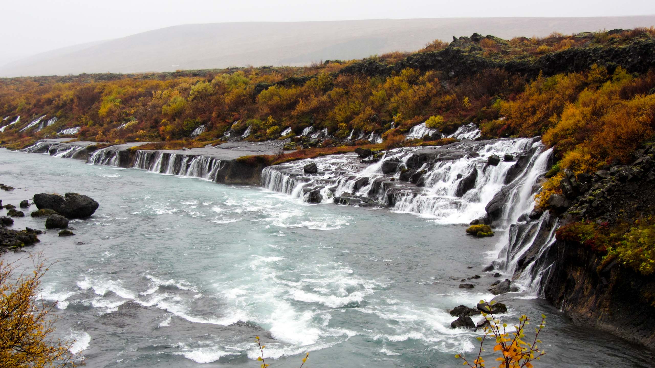 Small waterfalls run into an Iceland river