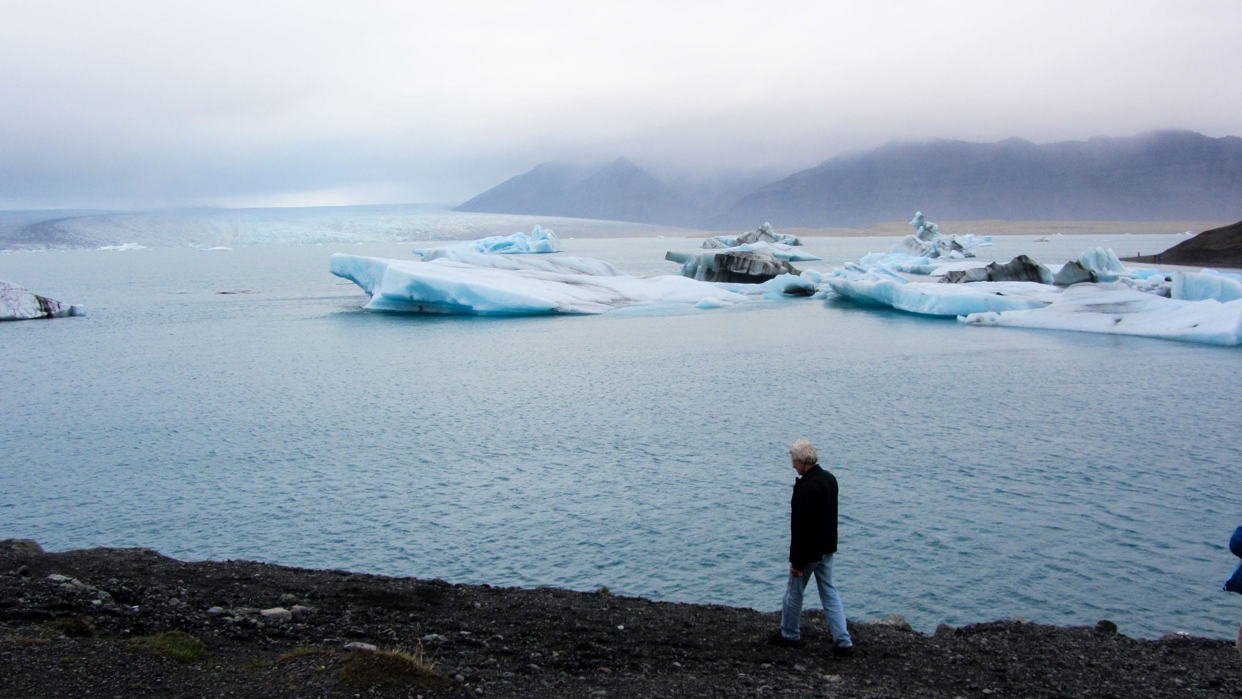 Traveler walks along Iceland shore