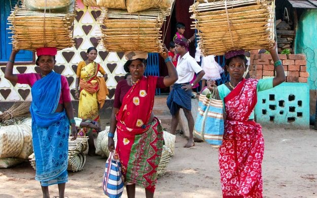 Women carrying baskets overhead in India