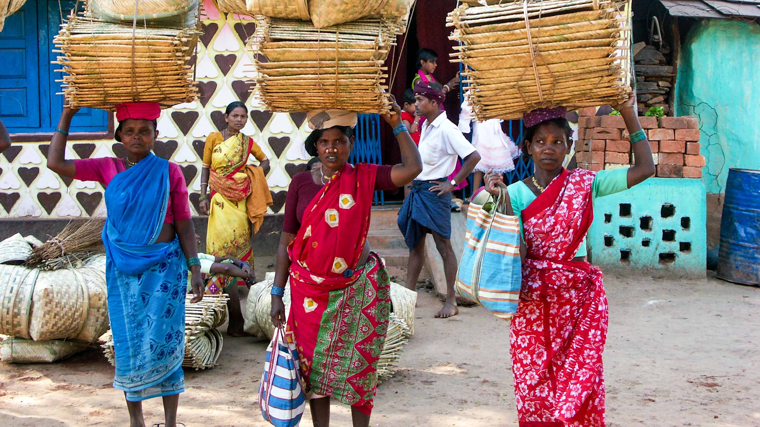 Women carrying baskets overhead in India