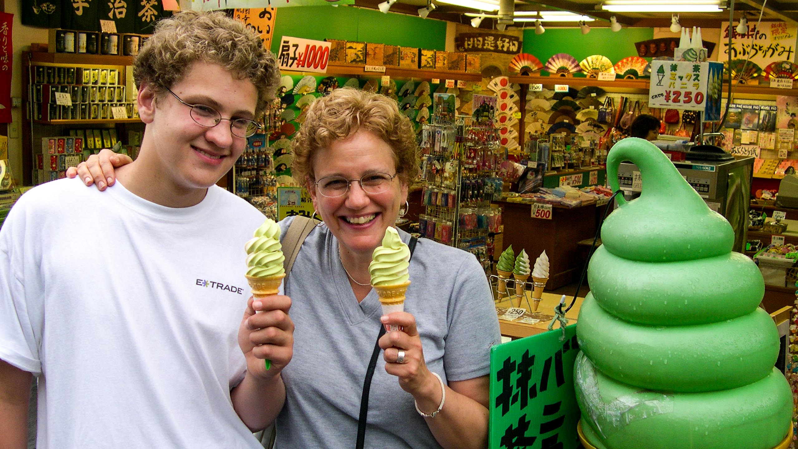 Teen boy and older woman hold ice cream cones