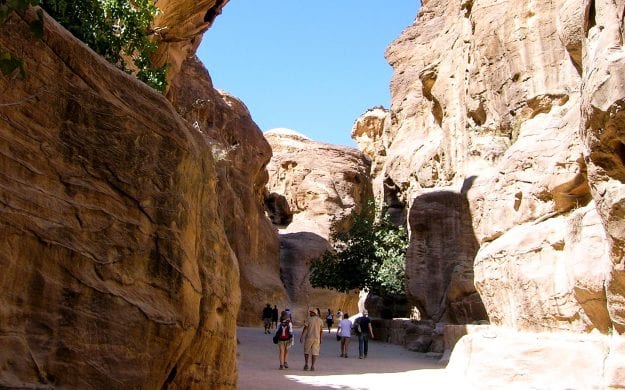 Travelers walk through valley between Jordan cliffs