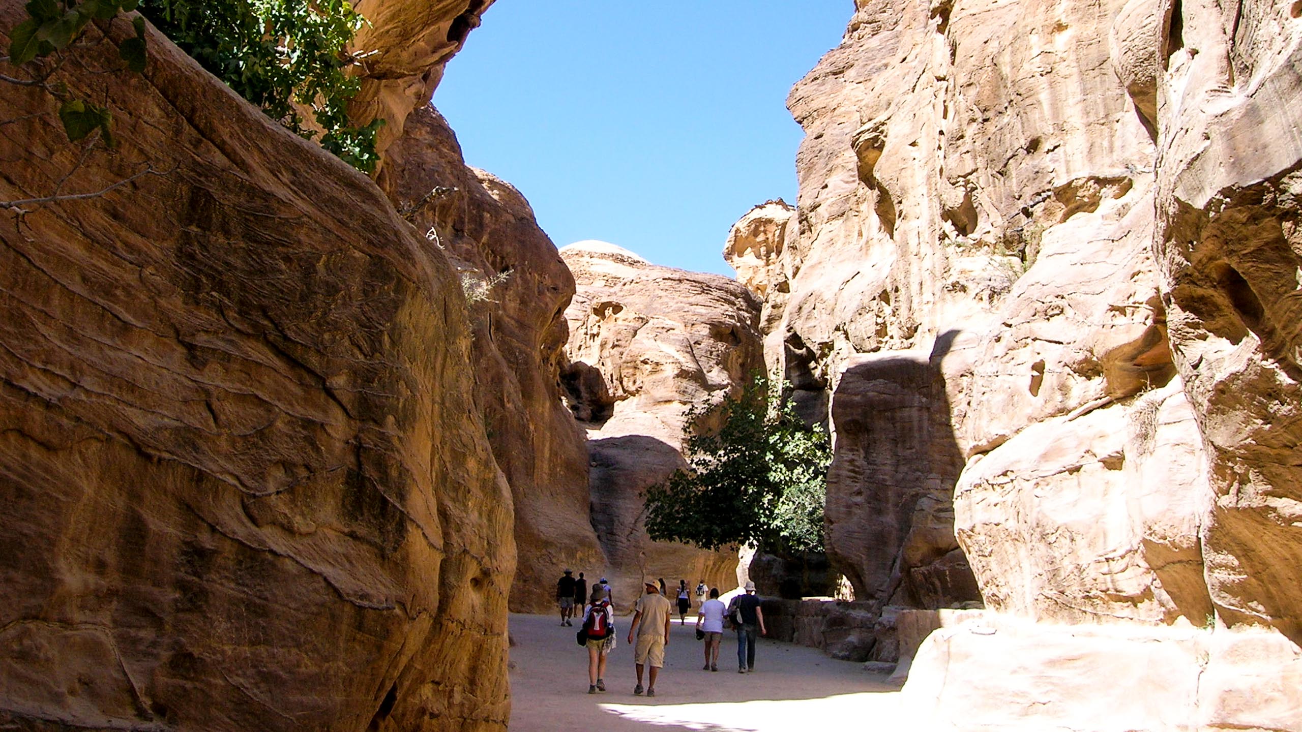 Travelers walk through valley between Jordan cliffs