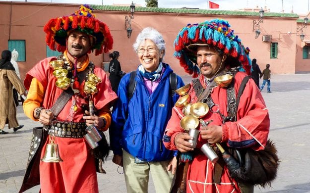 Woman stands with performers in Morocco