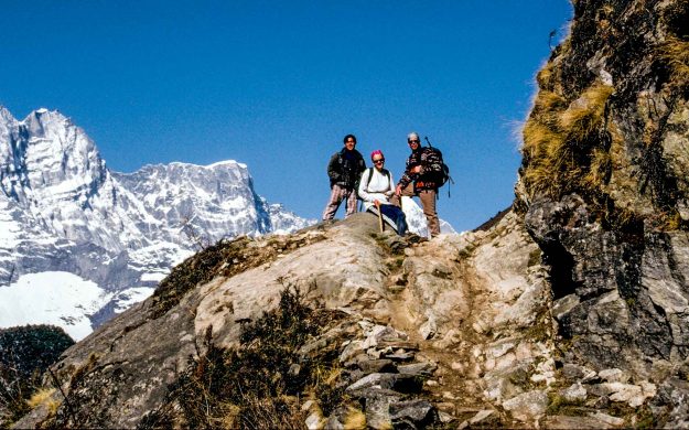 Everest hiking group rests on rock outcrop