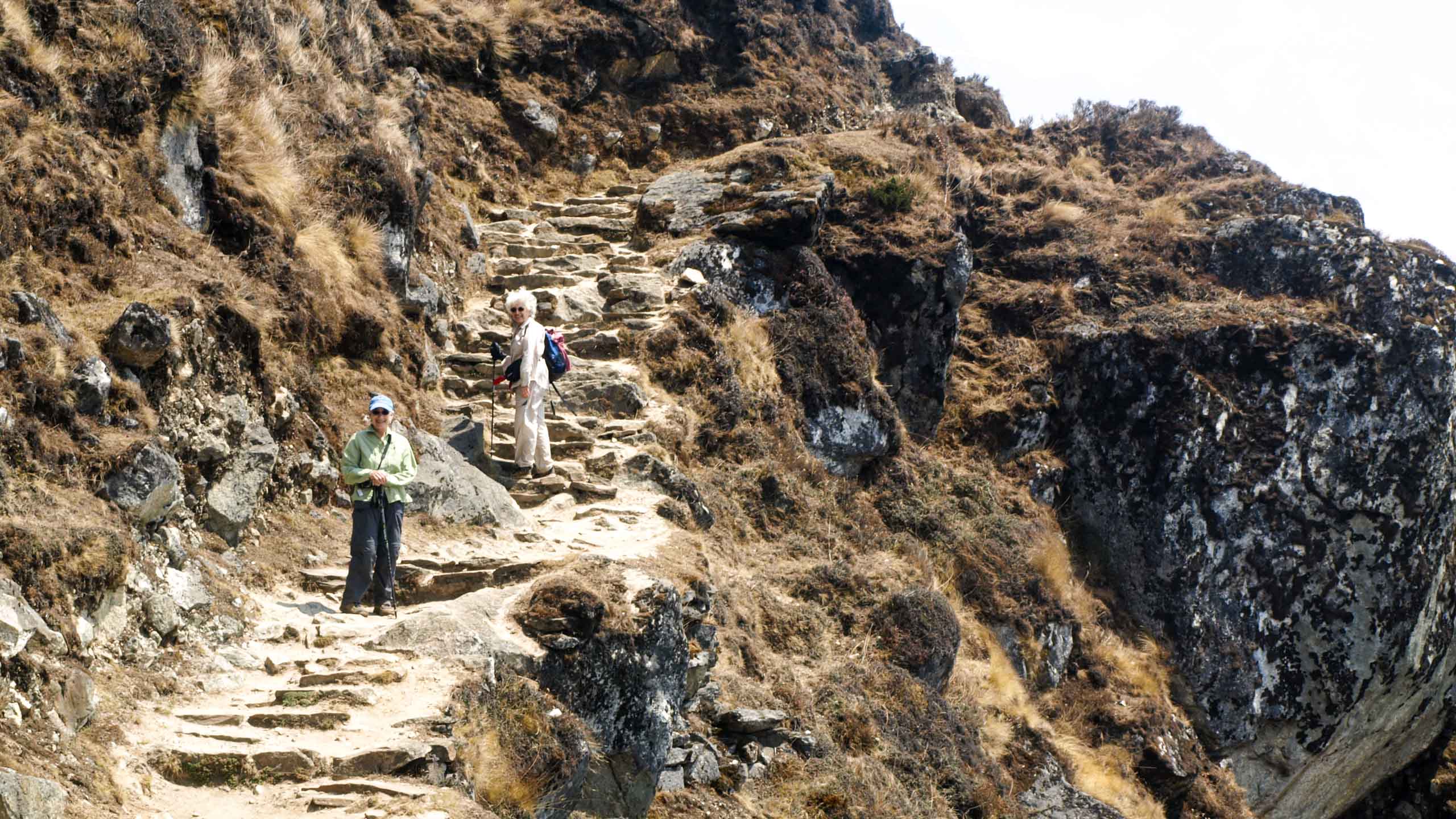 Nepal hikers climb cliffside trail