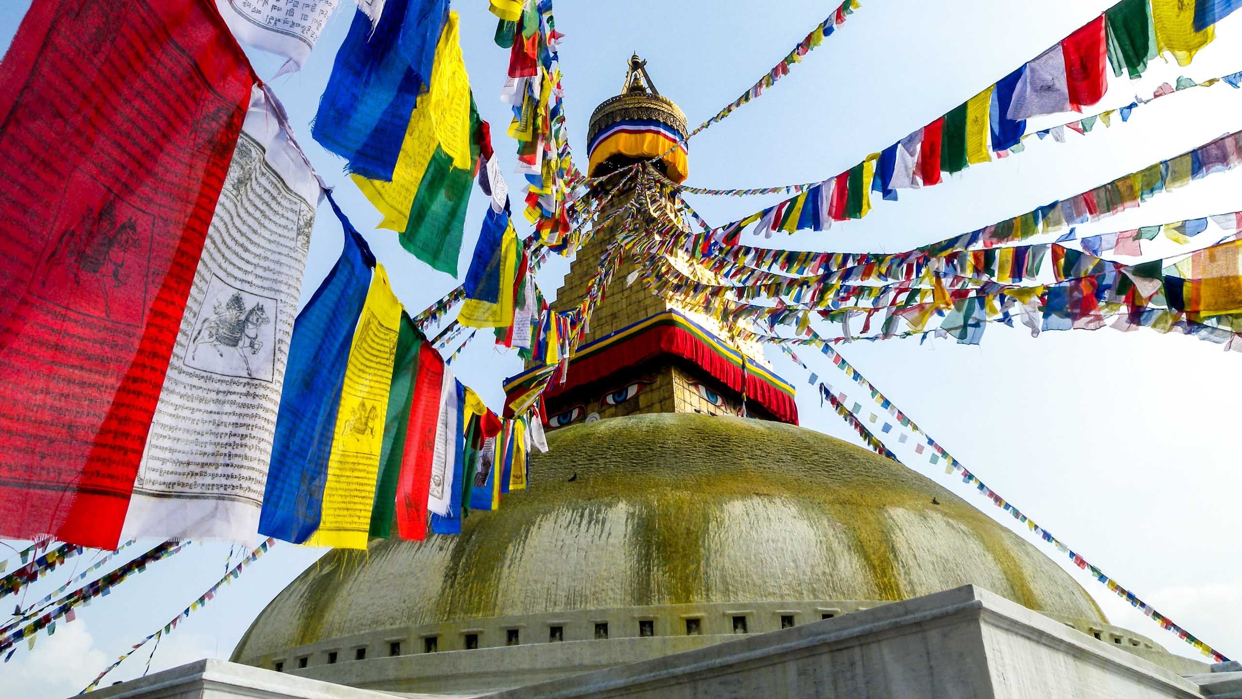 Colorful flags hang from spire of Nepal roof