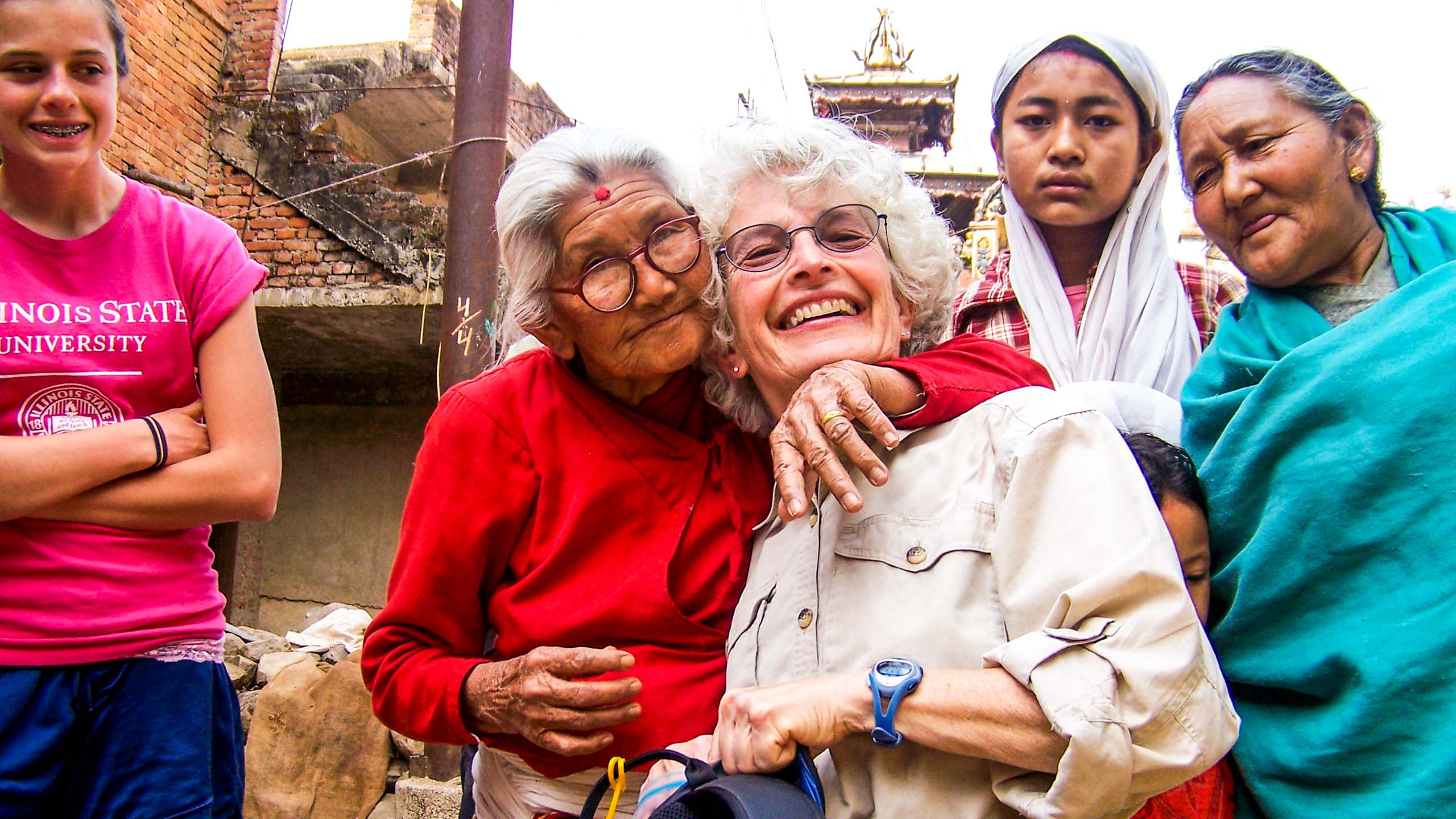 Nepal woman hugs smiling traveler