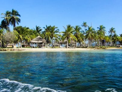 Panama beach with huts and palm trees