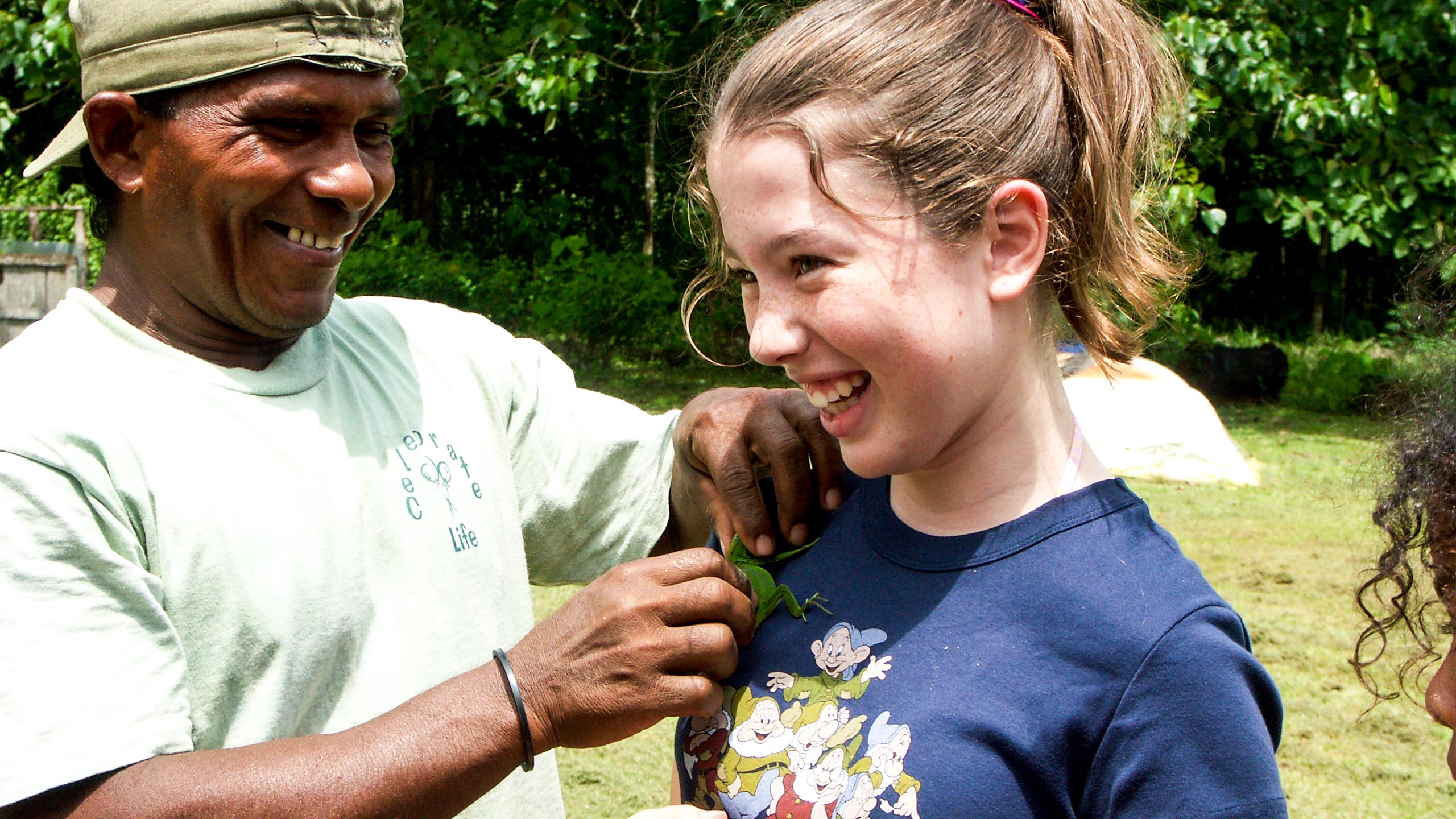 Panama man places lizard on girl's shoulder