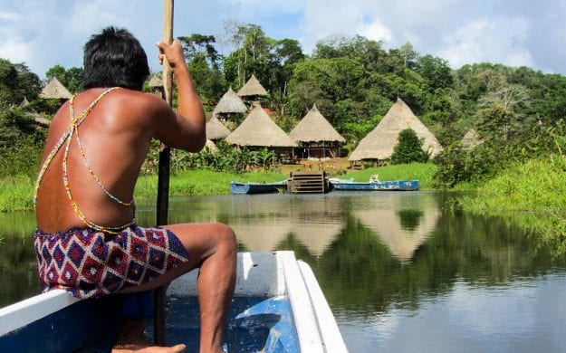 Panama man sits at front of boat approaching shore