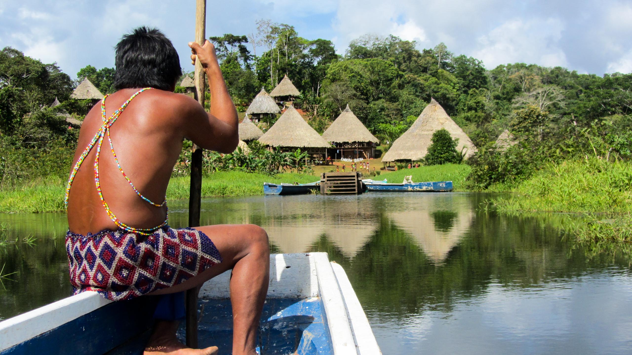 Panama man sits at front of boat approaching shore