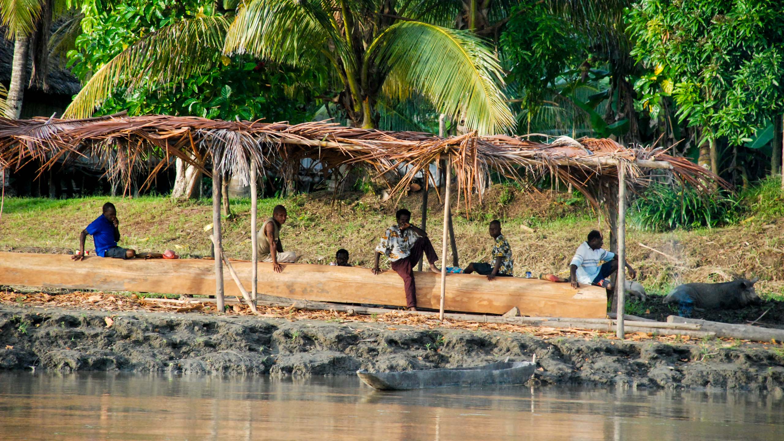 Papua New Guinea people sit on shore