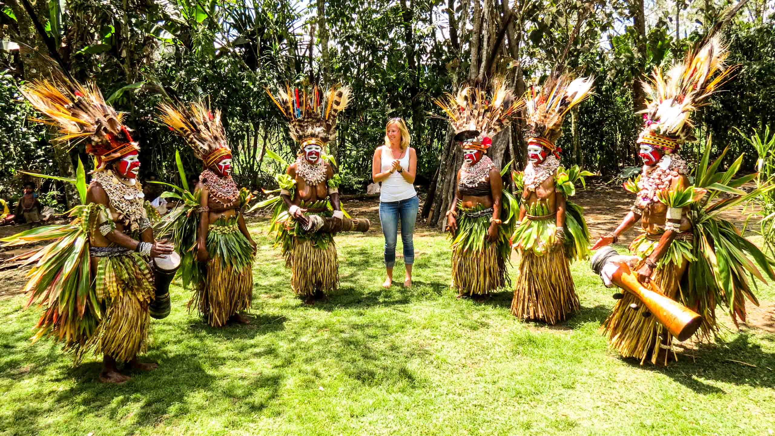 Traveler stands with group of Papua New Guinea natives