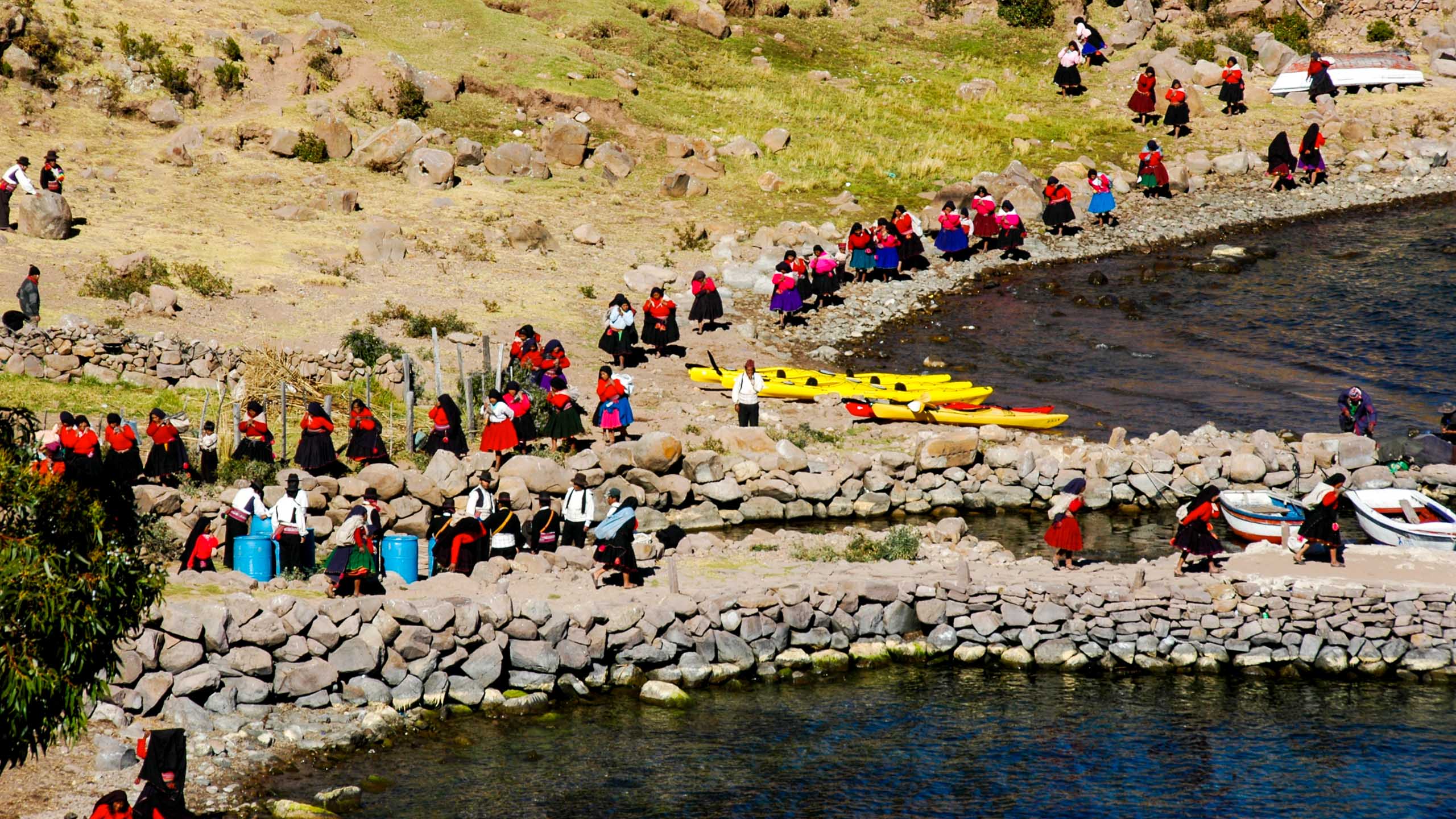 Group gathers around canoes waiting on shore
