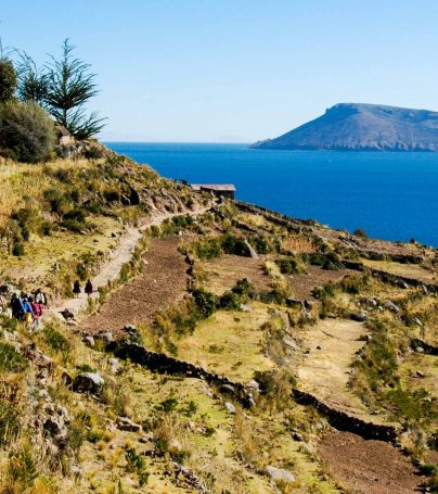 Travelers hike along shore in Peru