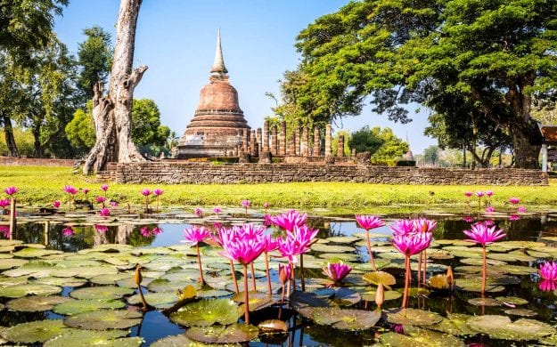 View of Sukhothai across lily pads on pond