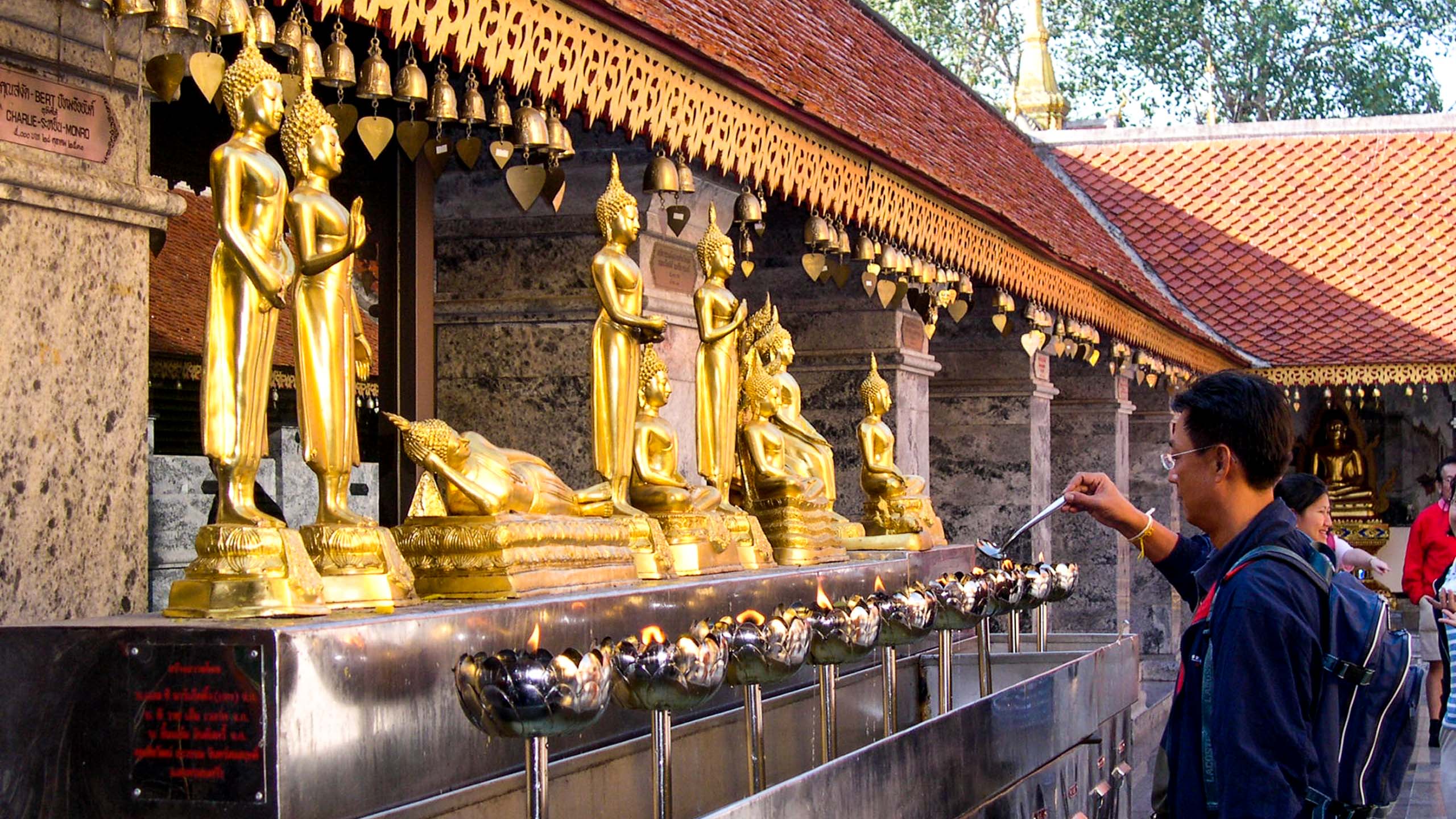 Thailand man lights candles at temple