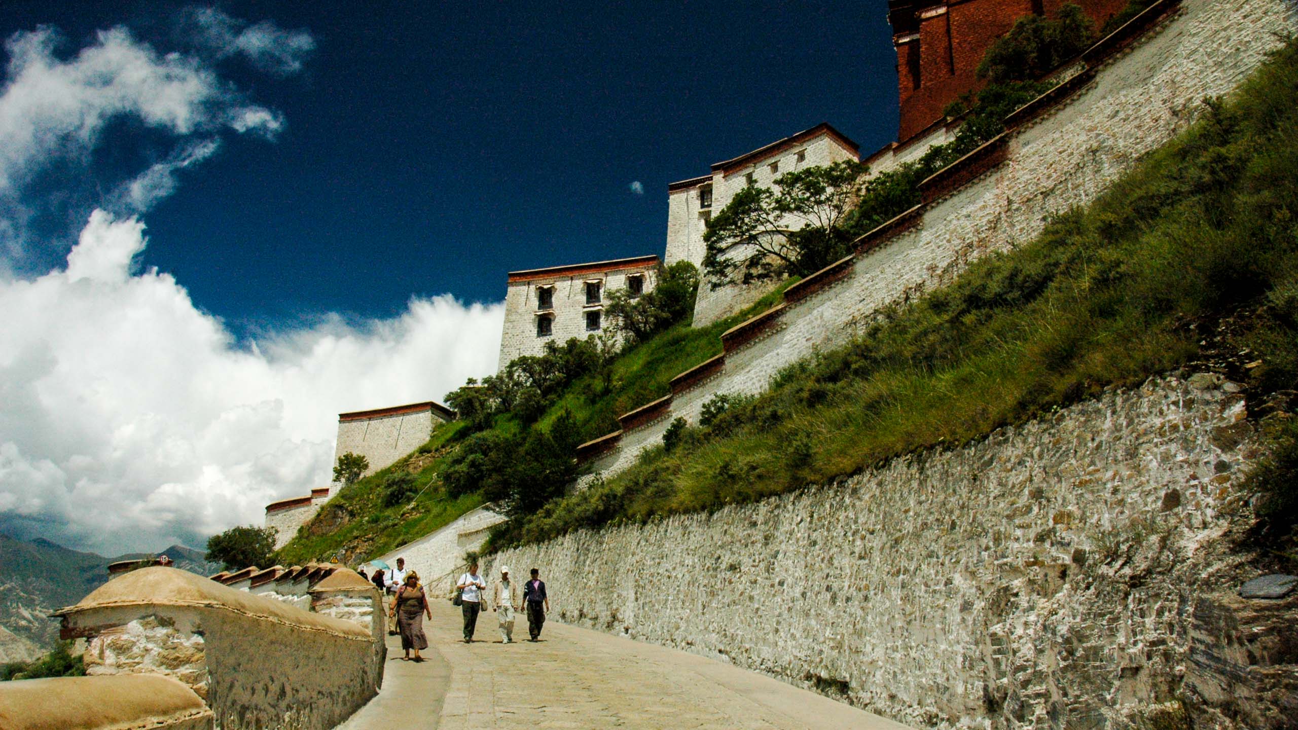 Travelers walk along path in Tibet town