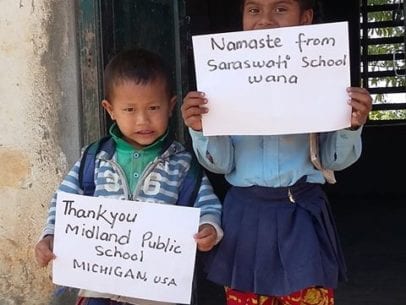 Children holding signs thanking the schools in Michigan