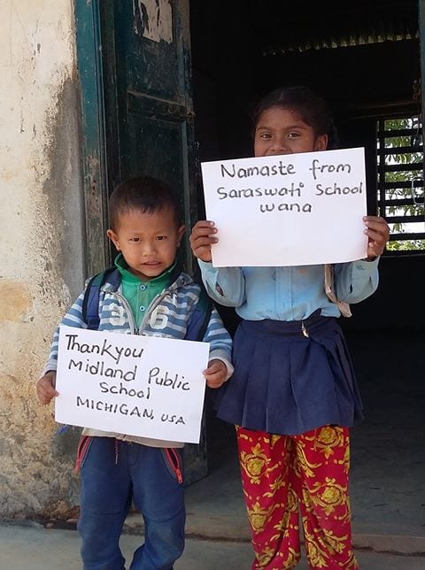 Children holding signs thanking the schools in Michigan