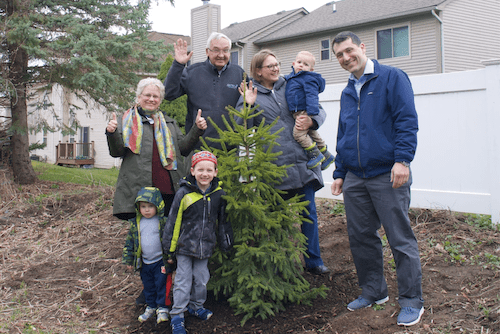 A family standing with a tree