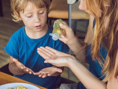 mom and kid using hand sanitizer