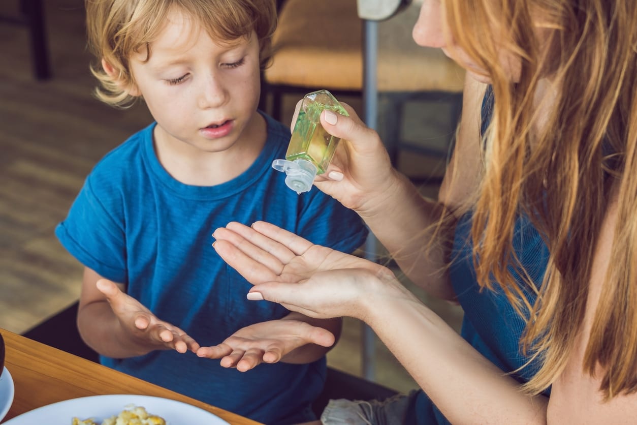 mom and kid using hand sanitizer