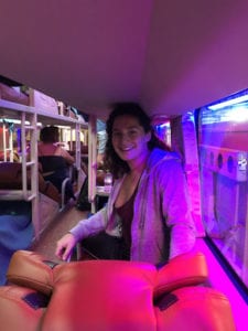 woman on sleeper bus with purple light