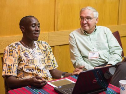 Paul Tamwenya sitting conversing with Will Weber