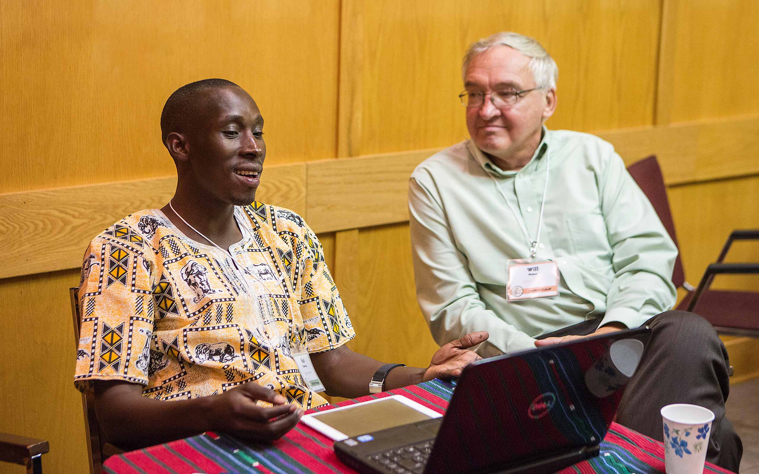 Paul Tamwenya sitting conversing with Will Weber