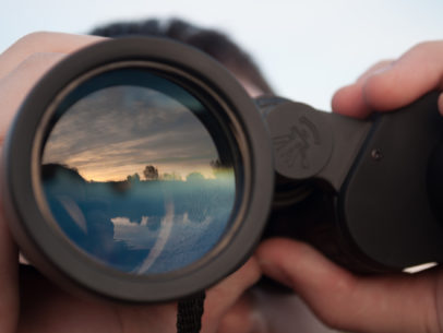 looking through binoculars
