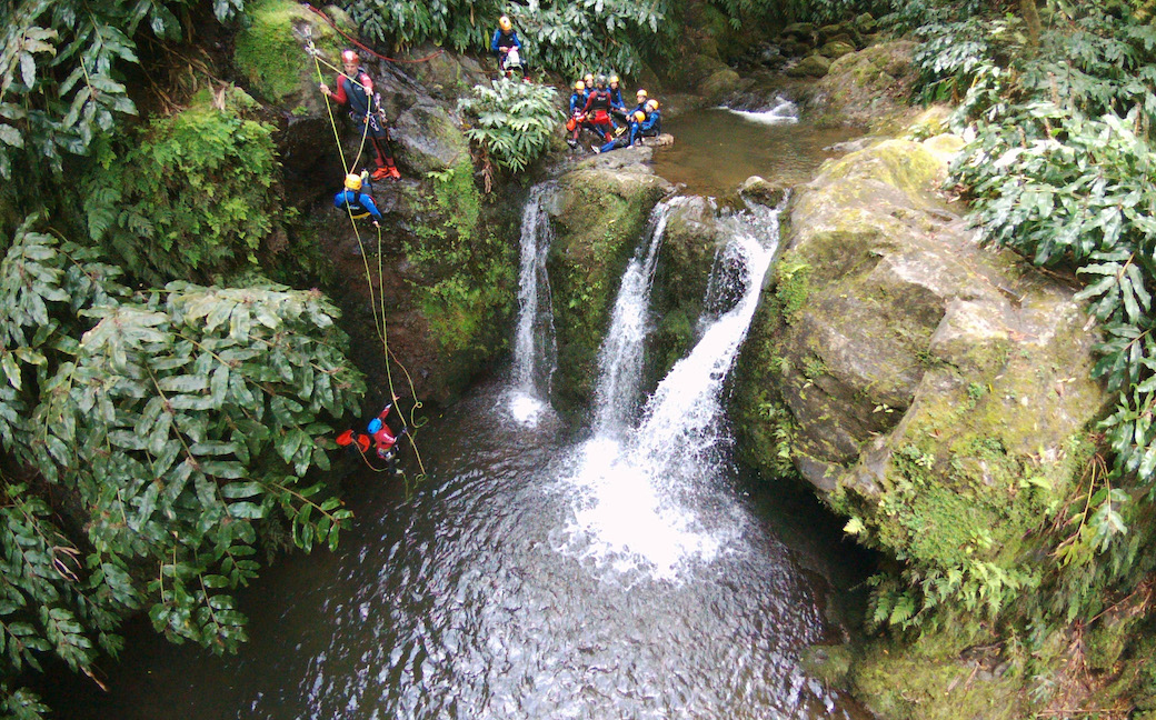 Group of people rappelling in a waterfall