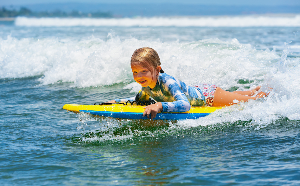 kid lying on surf board